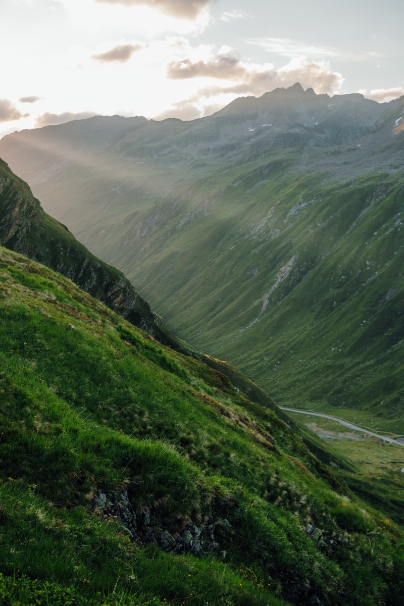 Sattgrüne Berghänge, über die Sonnenstrahlen durch die Wolken fallen
