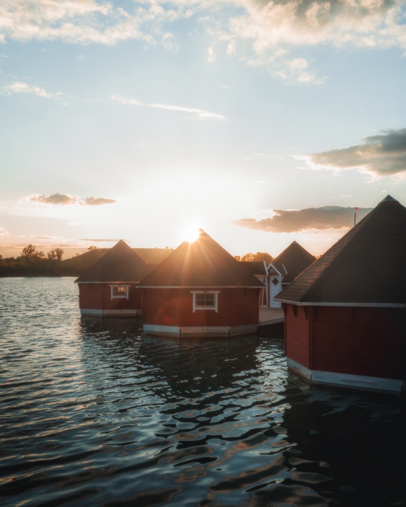 Rote Holzhütten am Wasser bei Sonnenuntergang
